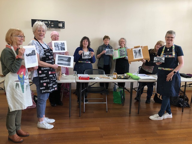 Students holding up their value studies learned in an oil painting class